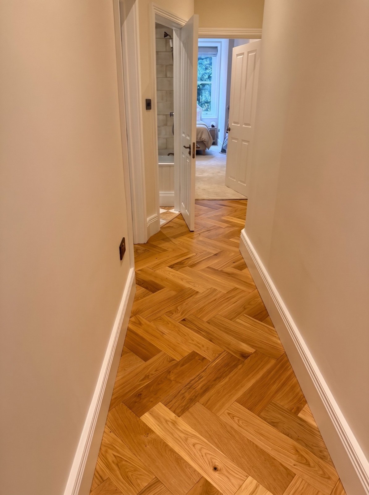Hallway with engineered oak herringbone flooring, torus skirting and new panelled doors
